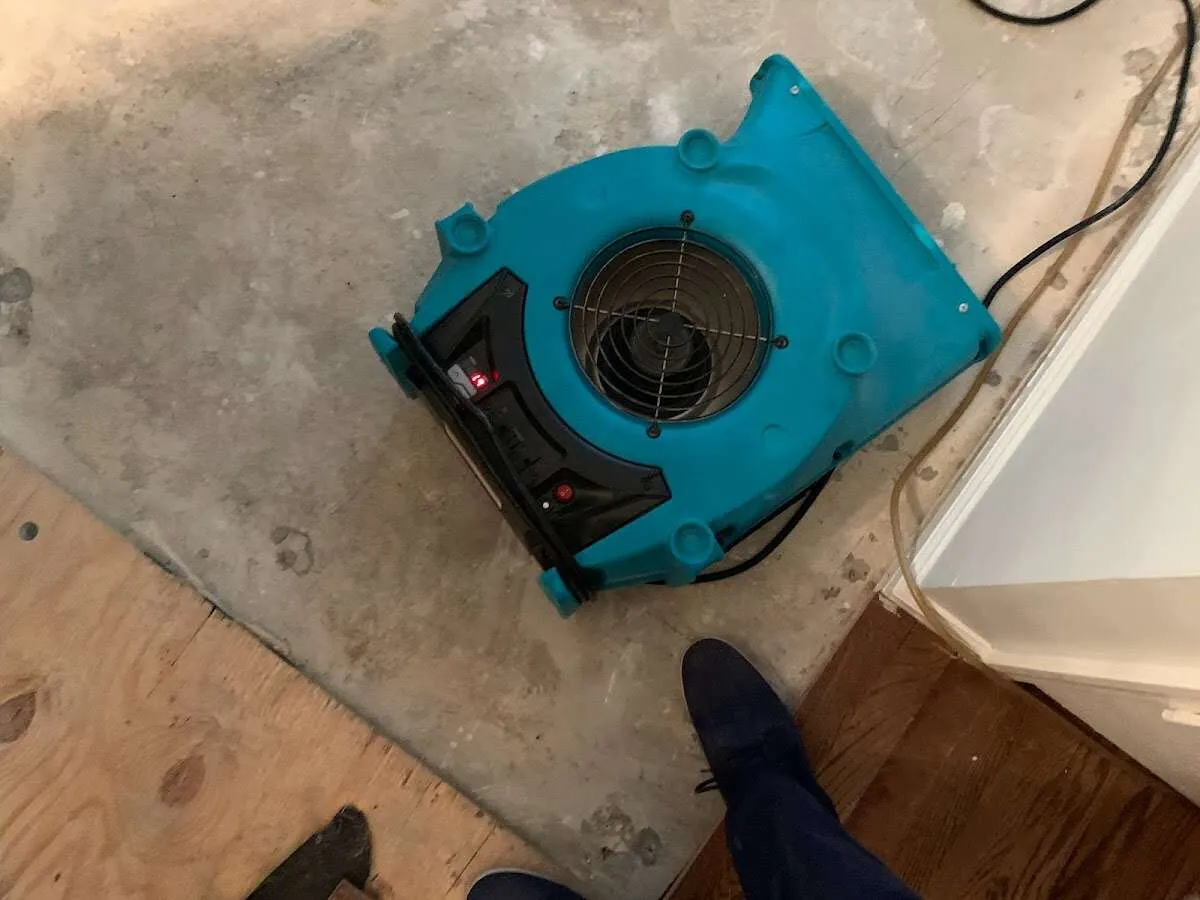 Air mover drying subfloor during Leak Detection & Repair in Manor